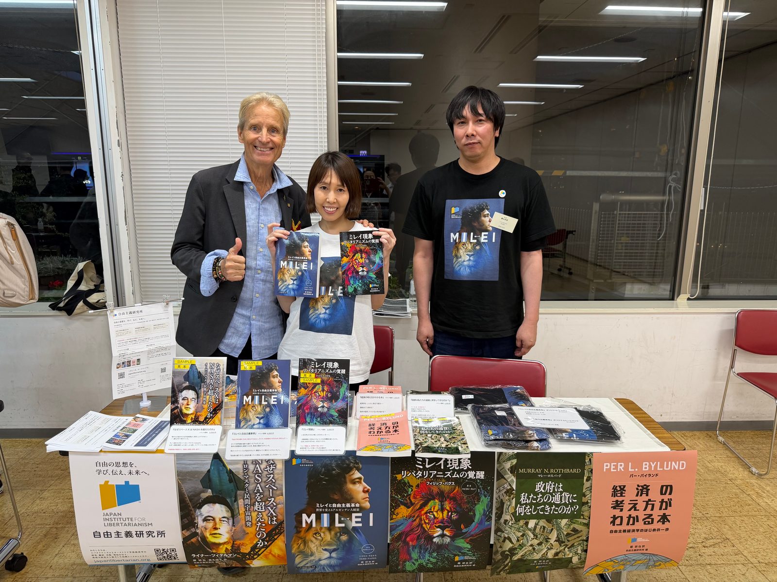 研究所の書籍を並べたブースの前で、クリストファー・リングルさん（左）と並んで撮った記念写真